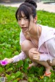 A woman crouching down with a flower in her hand.