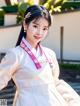 A woman in a white hanbok is posing for a picture.