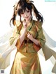 A woman in a yellow kimono with white wings.