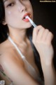 A woman brushing her teeth with a toothbrush.