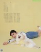 A woman laying on the ground with a white dog.