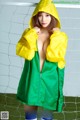 A woman in a green and yellow raincoat posing for a picture.