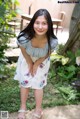 A woman in a blue top and white shorts posing for a picture.