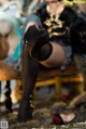 A woman in black stockings and high heels sitting on a chair.