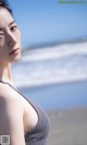 A woman standing on a beach next to the ocean.