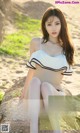 a woman in a white bikini sitting on a rock